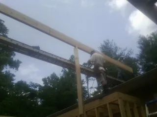 Carpenter setting a ridge beam over a new addition frame — Ice Dam Removal by Roofing Brothers in Kramer