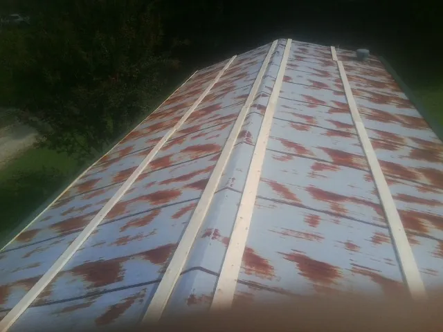 Rusted metal roof panels with new wood purlins before replacement — Storm Damage Roof Repair in Kramer by Roofing Brothers